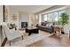 Bright living room features a stone fireplace, large windows, and modern furnishings at 21455 E 44Th Ave, Denver, CO 80249