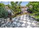 A checkered backyard patio is beautifully decorated with lush greenery and serene seating at 4293 Clover Ln, Brighton, CO 80601
