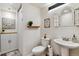 Well lit bathroom with white fixtures, decorative art and a storage cabinet at 4293 Clover Ln, Brighton, CO 80601