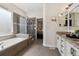 Elegant bathroom with a soaking tub, glass-enclosed shower, and granite countertops at 4293 Clover Ln, Brighton, CO 80601