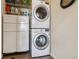 Efficient laundry area with stacked washer and dryer and convenient built-in storage at 4293 Clover Ln, Brighton, CO 80601