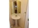 Powder room featuring a pedestal sink, mirrored vanity, and neutral decor at 1015 Alta St, Longmont, CO 80501