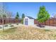 Backyard with a wooden fence, lush greenery, and a charming storage shed at 3195 S Kalispell Ct, Aurora, CO 80013