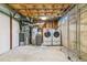 Basement laundry area with washer, dryer, and open ceiling, plus a metal storage rack at 3195 S Kalispell Ct, Aurora, CO 80013