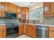 Well-equipped kitchen with wooden cabinetry, stainless steel appliances, and mosaic tile backsplash at 3195 S Kalispell Ct, Aurora, CO 80013