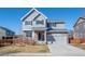 Charming two-story home featuring a stone facade, gray siding, and a two-car garage, set against a clear blue sky at 19603 E 63Rd Pl, Aurora, CO 80019