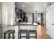 Modern kitchen with dark cabinets, a breakfast bar, stainless steel appliances, and an open view to the backyard at 19603 E 63Rd Pl, Aurora, CO 80019