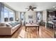 Well-lit living room featuring hardwood floors, neutral walls, a ceiling fan, and an open view to the kitchen at 19603 E 63Rd Pl, Aurora, CO 80019
