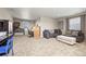Living room featuring neutral walls, carpet, sofa, game system, and desk at 19603 E 63Rd Pl, Aurora, CO 80019