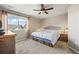 Comfortable bedroom with neutral walls, carpeted floor, a ceiling fan, and a bright window providing natural light at 19603 E 63Rd Pl, Aurora, CO 80019