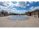 Closed outdoor pool with a sturdy cover, surrounded by a concrete pool deck and recreation buildings at 19603 E 63Rd Pl, Aurora, CO 80019