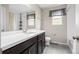 Bright bathroom featuring single vanity, large mirror, and a shower-tub combination at 21833 E Quincy Pl, Aurora, CO 80015