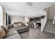 Living room with gray modern sofa and hardwood flooring leading to the kitchen with a counter at 21833 E Quincy Pl, Aurora, CO 80015