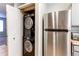 Convenient laundry closet with stacked washer/dryer, next to stainless steel refrigerator at 4246 S Eldridge St # 103, Morrison, CO 80465
