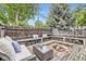Backyard area with a wooden deck, fire pit, and cushioned outdoor seating at 1292 Kearney St, Denver, CO 80220