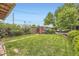 Well-maintained backyard with lush lawn, tidy garden beds, and mature trees under a clear blue sky at 1292 Kearney St, Denver, CO 80220
