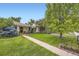 Charming home featuring a well-manicured lawn and mature trees under a clear blue sky at 1292 Kearney St, Denver, CO 80220
