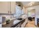 Farmhouse style kitchen with stainless steel appliances, modern cabinetry, and a stylish dark stone countertop at 1292 Kearney St, Denver, CO 80220