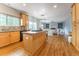Modern kitchen featuring wood cabinets, stainless steel appliances, and an island with a cooktop, seamlessly connecting to living at 2822 Flint Ct, Superior, CO 80027