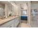 Bathroom featuring double sinks, granite countertops, and a glass-enclosed shower at 400 E Fremont Pl # 205, Littleton, CO 80122