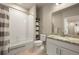 Bathroom with a granite countertop, white cabinetry, and shower with gray and white striped curtain at 400 E Fremont Pl # 205, Littleton, CO 80122