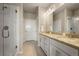 Beautiful bathroom featuring granite countertops, dual sinks, and a glass shower enclosure at 400 E Fremont Pl # 205, Littleton, CO 80122