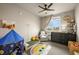 Bright bedroom features a ceiling fan, large window, and playful decor at 400 E Fremont Pl # 205, Littleton, CO 80122