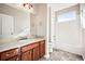Neutral toned bathroom with a large mirror over a wooden vanity and a shower with tub combo at 461 Saber Creek Dr, Monument, CO 80132