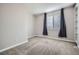 Carpeted bedroom featuring a window with dark curtains and neutral colored walls and trim at 461 Saber Creek Dr, Monument, CO 80132