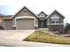 Inviting two-story home with stone accents, a well-manicured lawn, and a two-car garage, perfect for families at 461 Saber Creek Dr, Monument, CO 80132