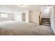 Open living room featuring neutral walls, carpet flooring and wooden staircase leading to the second level at 461 Saber Creek Dr, Monument, CO 80132