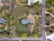 Aerial view of a home with surrounding mature trees and a well-manicured lawn, adjacent to a quiet street at 4901 Redwood Dr, Littleton, CO 80123