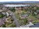 Aerial view of a home featuring mature trees and established landscaping near a serene lake with mountain views at 4901 Redwood Dr, Littleton, CO 80123