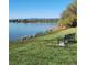 Scenic lake view featuring a bench on the grassy shore, with mountains visible in the distance on a clear day at 4901 Redwood Dr, Littleton, CO 80123