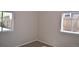 Corner bedroom featuring neutral walls, carpet flooring, and dual windows with backyard views at 1750 Jamaica St, Aurora, CO 80010