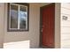 Close-up of the front door, showcasing its rich color and adjacent window for natural light at 1750 Jamaica St, Aurora, CO 80010