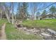 Picturesque creek flowing through a grassy landscape with mature trees at 23566 Pondview Pl # F, Golden, CO 80401