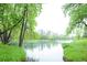Picturesque view of the tranquil pond, framed by vibrant green trees, creating a serene natural setting at 23566 Pondview Pl # F, Golden, CO 80401