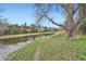 Scenic view of a calm pond surrounded by lush greenery and mature trees at 23566 Pondview Pl # F, Golden, CO 80401