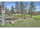 Community pond with surrounding greenery, mature trees, and nearby parking at 23566 Pondview Pl # F, Golden, CO 80401