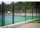 Fenced tennis court with blue and green surface, located in a wooded area at 23566 Pondview Pl # F, Golden, CO 80401