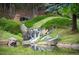 Picturesque waterfall cascading over rocks in a lush, green setting at 23566 Pondview Pl # F, Golden, CO 80401
