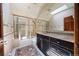 Bright bathroom featuring tiled walls, black vanity, marble countertop, shower with glass door and decorative tiling on the floor at 850 E Radcliff Ave, Cherry Hills Village, CO 80113