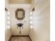 Stylish powder room with custom mirror, sink, wall sconces, and stone flooring at 850 E Radcliff Ave, Cherry Hills Village, CO 80113