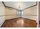 Bedroom with wood floors, baseboard heating, accent molding and a corner window providing natural light at 850 E Radcliff Ave, Cherry Hills Village, CO 80113