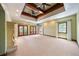 Spacious carpeted bedroom featuring a tray ceiling with fans, french doors to the exterior, and a stone fireplace at 850 E Radcliff Ave, Cherry Hills Village, CO 80113