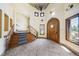 Elegant foyer featuring a grand staircase, stone floors, chandelier, and arched wood door at 850 E Radcliff Ave, Cherry Hills Village, CO 80113