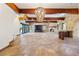 Expansive living room features stone fireplace, exposed wood beams, floor-to-ceiling windows and stone floors at 850 E Radcliff Ave, Cherry Hills Village, CO 80113