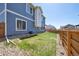 Backyard with a wooden fence, grass area, rocks, and an in-ground sprinkler system at 10207 Xanadu St, Commerce City, CO 80022