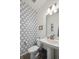 Stylish half bath featuring modern fixtures and designer wallpaper adding a touch of elegance at 10207 Xanadu St, Commerce City, CO 80022